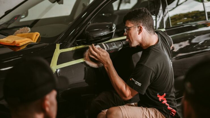 A man meticulously polishes a car, showcasing precision in an automotive workshop. - Photo by Geancarlo Peruzzolo on Pexels