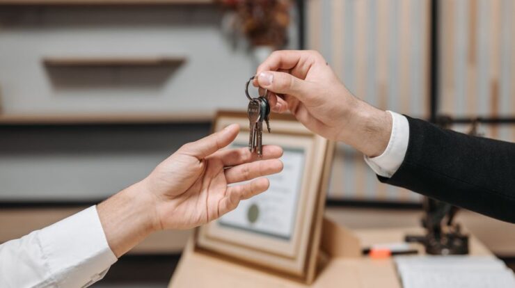 Detailed view of hands exchanging keys in a professional office environment, symbolizing real estate or business transactions. - Photo by Pavel Danilyuk on Pexels